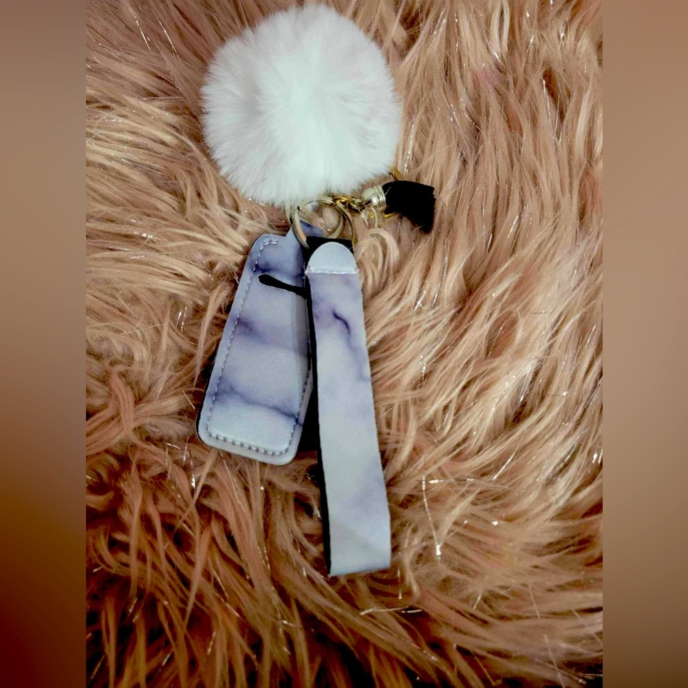White and black marble effect wristlet with chapstick holder and fuzzy ball